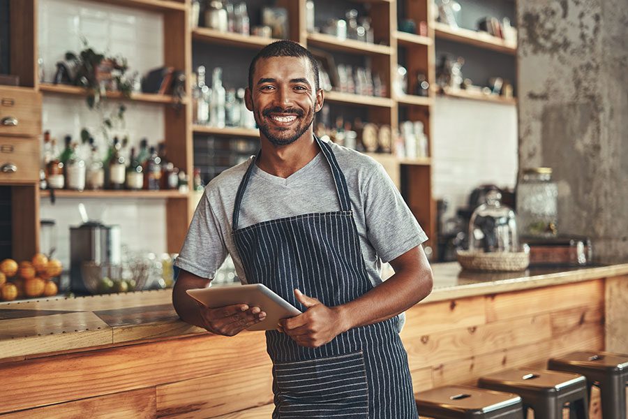 Business Insurance - African American Man Cafe Worker Holding iPad