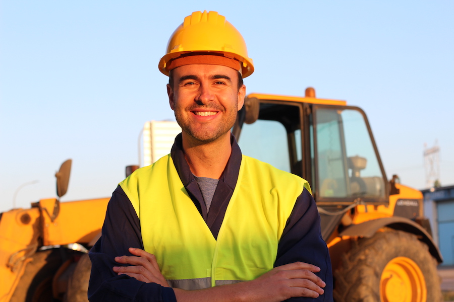 Contractor - Construction driver with excavator on the background